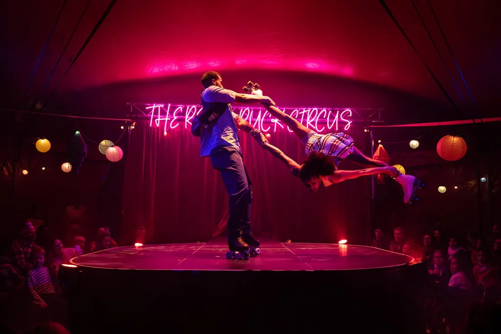 Families in the front rows of the Revel Puck big top in Walthamstow watch a roller-skating duo spin