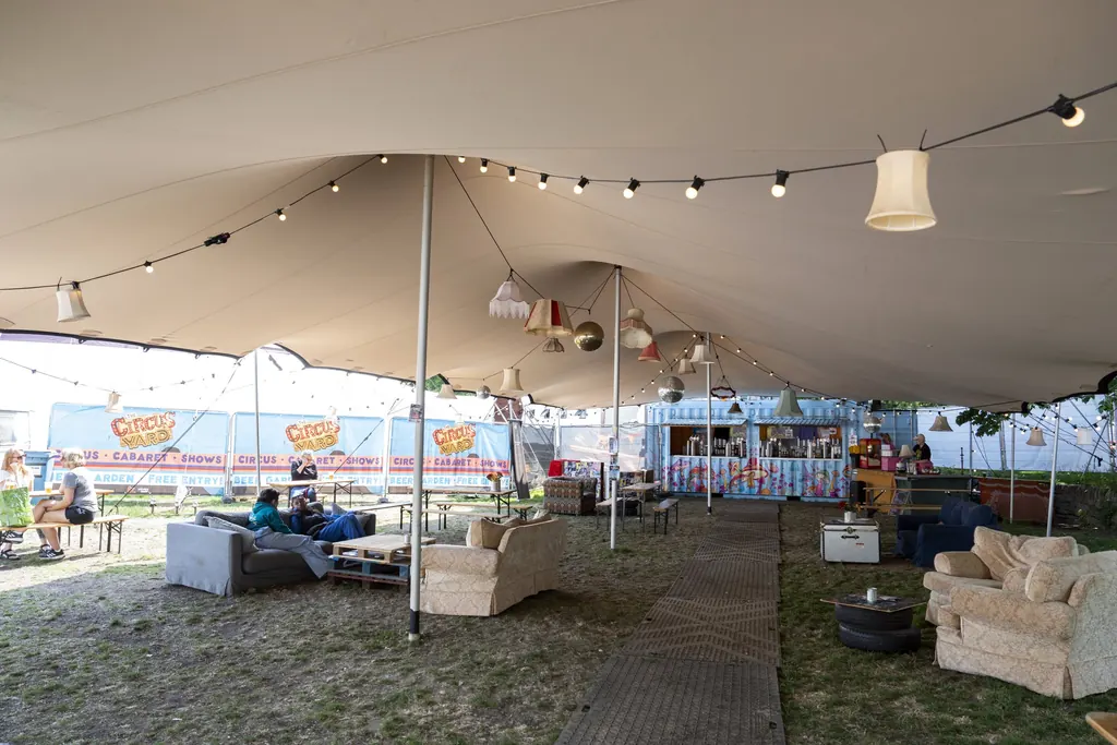 Inside our stretch tent: sofas, lampshades and festoon lights